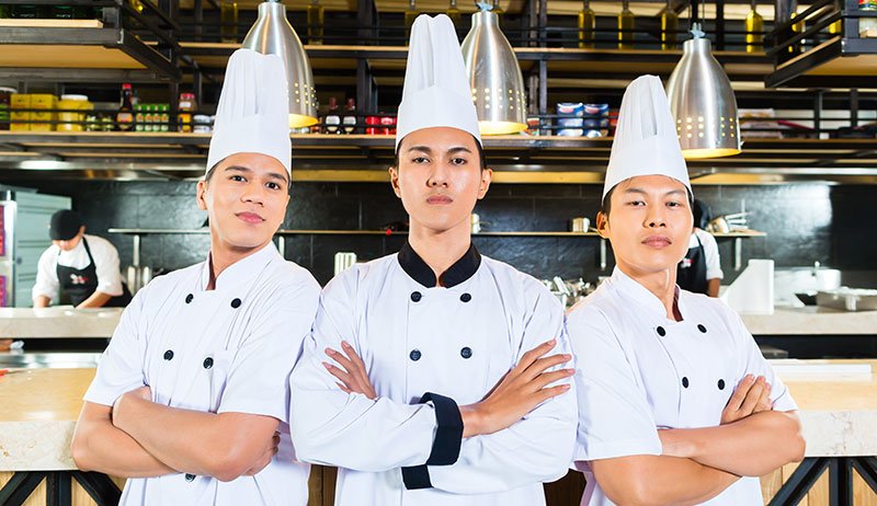 Young chefs standing with arms crossed